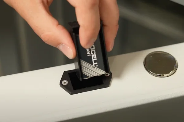 Einsetzen einer 9-Volt-Batterie in das externe Batteriefach eines Tresors zur Notstromversorgung des Elektronikschlosses