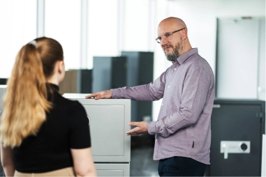 Ein HARTMANN-TRESORE-Mitarbeiter präsentiert einer Kundin einen Tresor im Showroom
