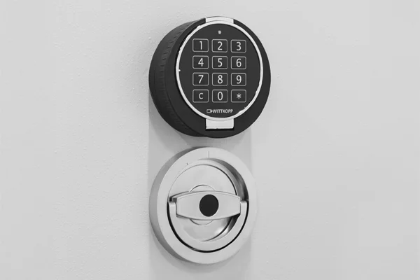 Elektronikschloss E70611 von WITTKOPP mit Klappgriff an einer hellen Tresortür