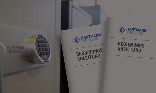 Elektronisches Tresorschloss an einem Hartmann Tresor, daneben zwei Bedienungsanleitungen mit dem Hartmann Tresore-Logo. Fokus auf Sicherheit und Benutzerfreundlichkeit durch hochwertige Tresortechnologie.